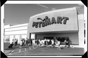 A group of people standing outside of a petsmart store.